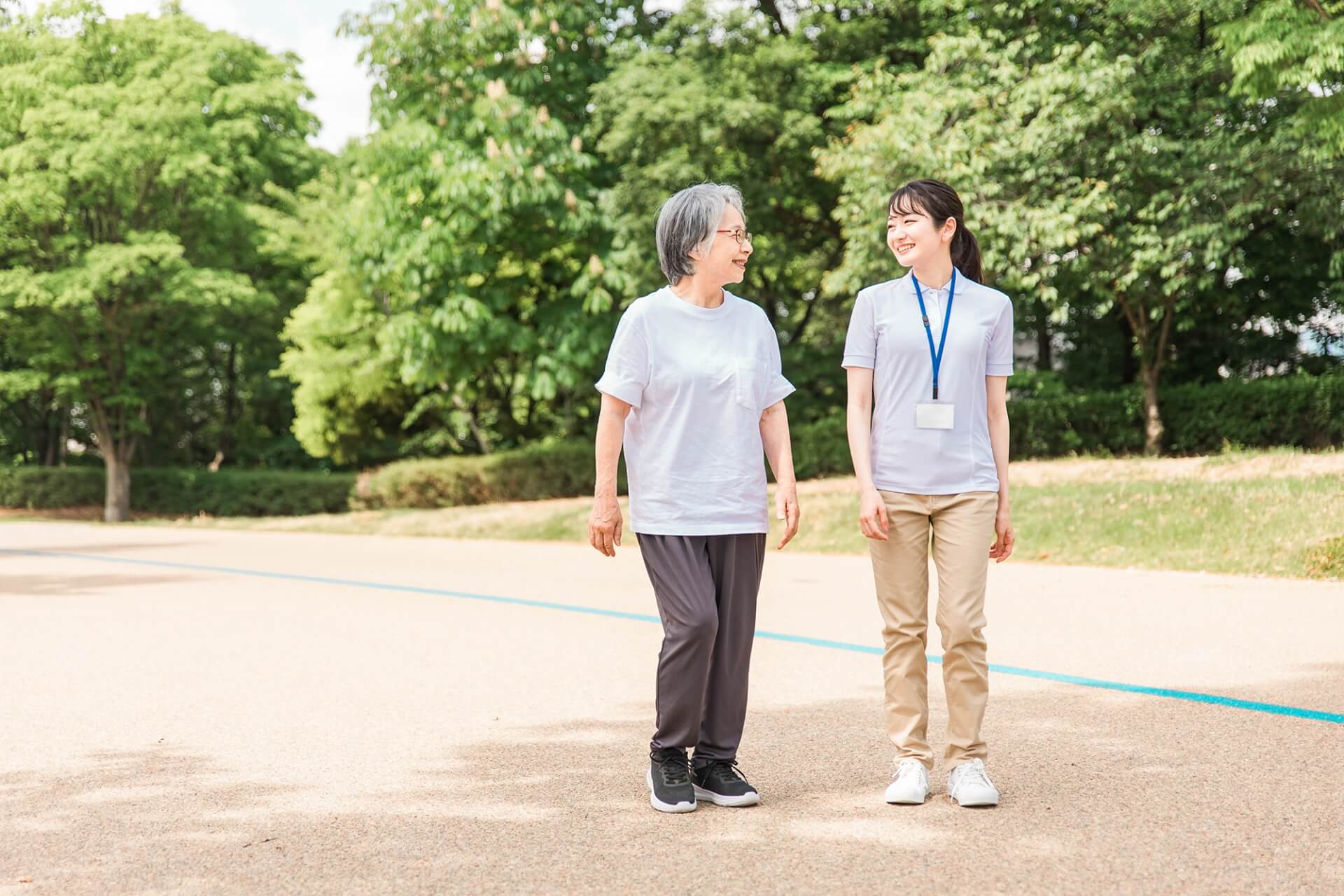 ご高齢女性の外出/散歩に付き添う介護/看護スタッフの写真
